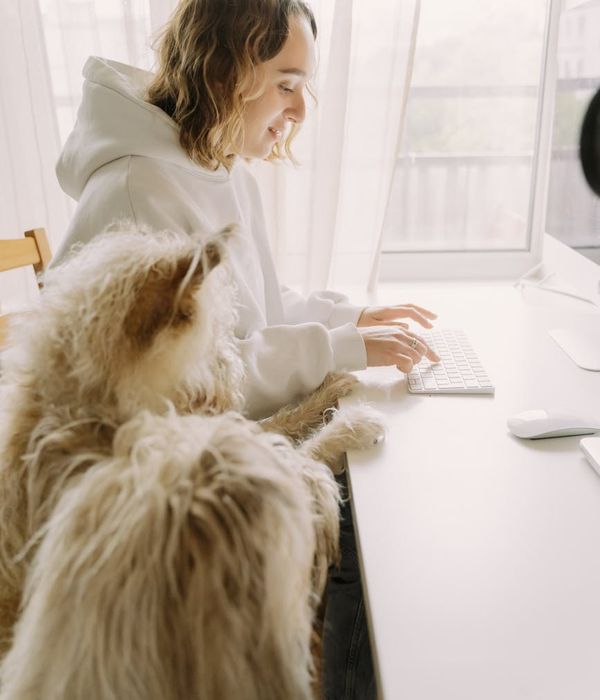 Woman looking away from a computer screen, with a calm and relaxed expression.